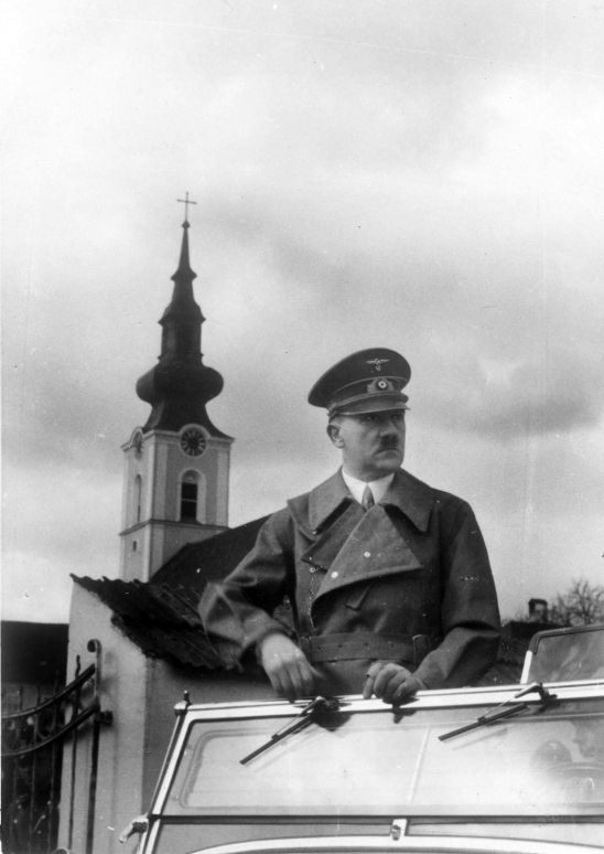 Adolf Hitler im offenen Auto vor der Pfarrkirche Leonding